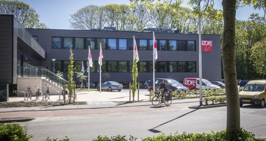 Zeven artsen-microbioloog van Izore, Centrum Infectieziekten Friesland, in Leeuwarden zijn sinds mei 2019 gestart met de spraakherkenningsoplossing SpeechReport Cursor voor het creëren van verslagen. De artsen dicteren rechtstreeks in Glims, het laboratorium informatiesysteem van MIPS.  De spraakherkenningssoftware, SpeechReport Cursor, is gebaseerd op de spraakengine van Recognosco. Een groot voordeel van deze engine is de mogelijkheid om voorafgaand aan de installatie woordenlijsten toe te voegen voor een optimale herkenning. Aangezien dit de eerste microbiologie-afdeling is die live ging met deze oplossing werden door middel van pre-adaptatie de namen van schimmels, parasieten, virussen en bacteriën toegevoegd aan het medisch woordenboek, alsook de namen van aanvragers van diagnostiek. Aan deze recent toegevoegde woorden wordt automatisch de Nederlandse klank gekoppeld. Hierdoor is de herkenning vanaf de start veel nauwkeuriger dan bij een eerder gebruikte oplossing.  Deze pre-adaptatie werd samen met de gebruikerstraining in één dag uitgevoerd. Hierna konden de artsen direct aan de slag met het creëren van verslagen.  Marisca Visser – Secretaresse afd. Medische Microbiologie vertelt: “Deze week meldde een van de artsen nog dat hij verbaasd was dat de meeste namen van de specialisten direct goed gespeld werden. Dit was voorheen echt wel anders. Wat een voordeel is geweest, is dat we deze namen, maar ook die van alle virussen, bacteriën etc. vooraf hebben ingelezen. Dat heeft echt een positief effect gehad op de herkenning.”  Op een drukke dag worden door de artsen-microbioloog met behulp van SpeechReport Cursor zo’n 50 à 60 consultteksten per dag/per persoon ingesproken in Glims. De uitslag vanuit Glims gaat naar de aanvrager, maar de consulttekst is voor intern gebruik.  Voor het versturen van de uitslag bespreekt de arts-microbioloog telefonisch de bevindingen en daarbij een therapieadvies met de aanvrager. Het besprokene wordt gedicteerd bij de uitslag in het consultveld. Deze tekst is bedoeld als naslag voor de arts-microbioloog zelf als ook zijn collega.